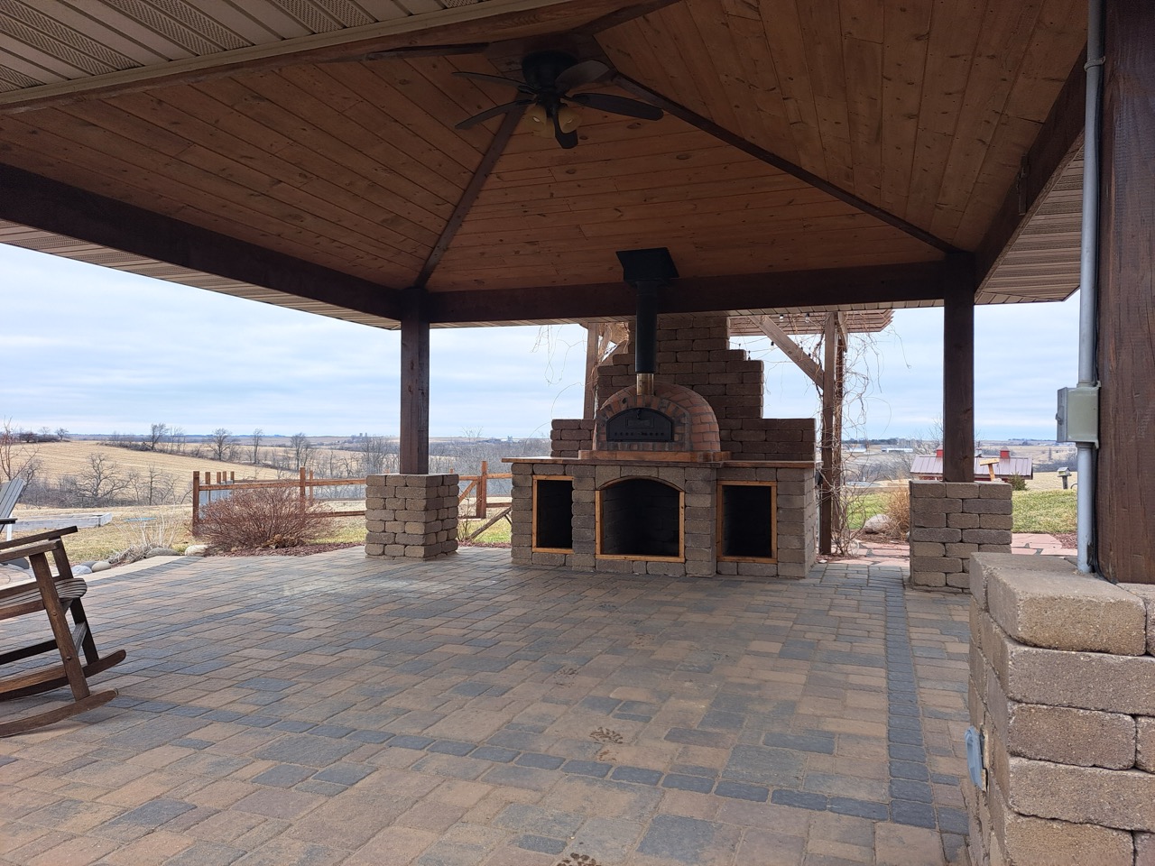 Covered paver patio with built-in outdoor pizza oven and kitchen