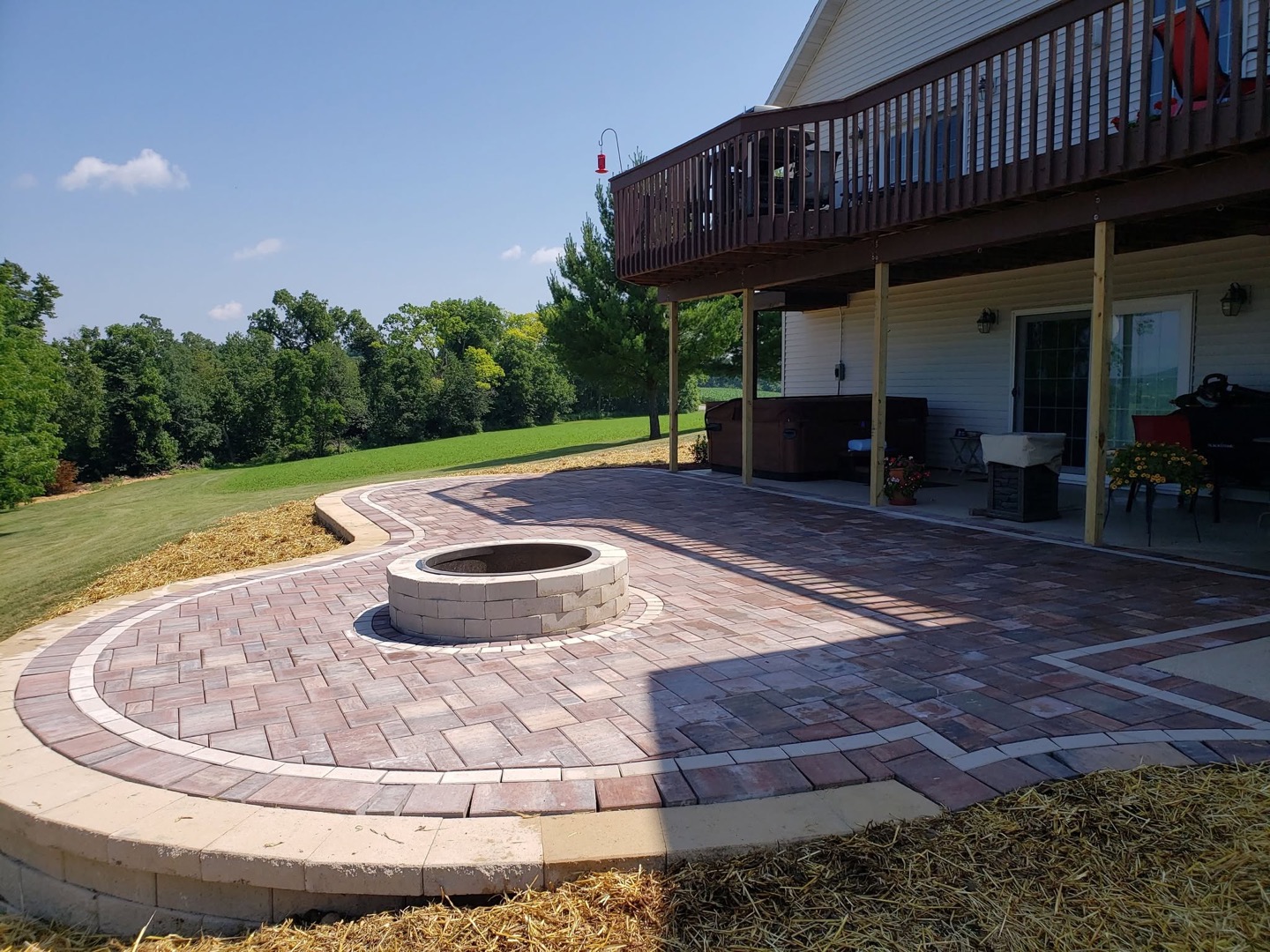 Custom paver patio with fire pit and open backyard overlook