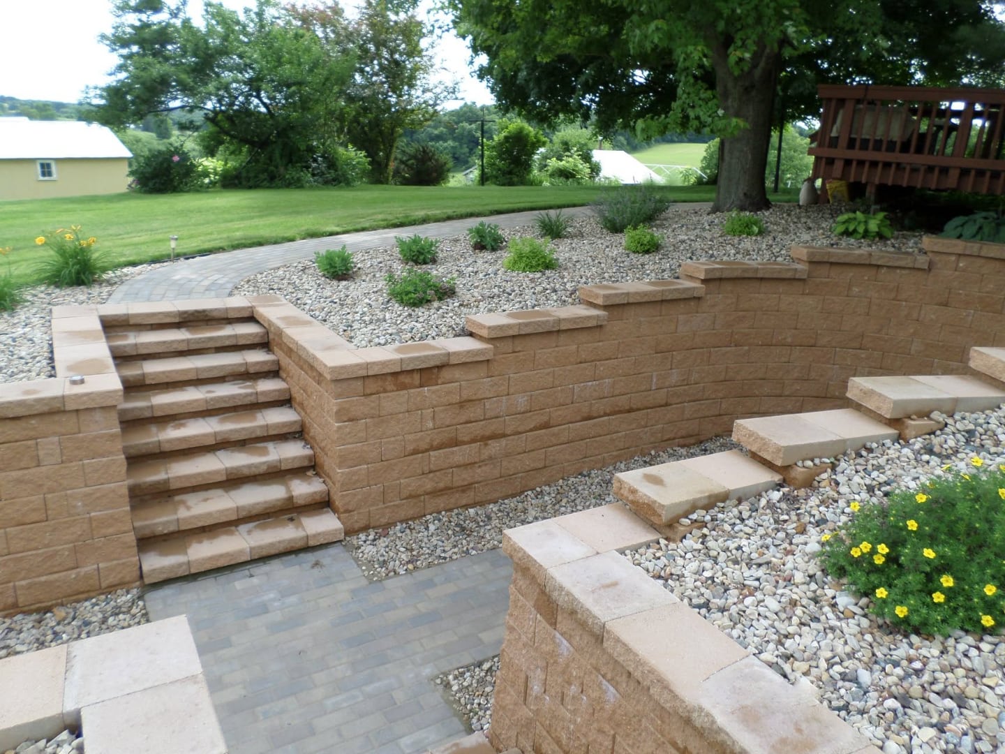 Tiered retaining wall with stone steps and planting bed in Platteville, WI